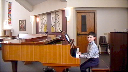 student Finnegan playing a grande piano