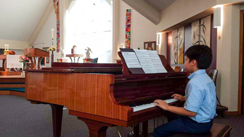 student Michael playing a grande piano