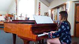 student Kelly playing a grande piano