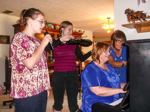 Joy teaching a piano student and a voice student